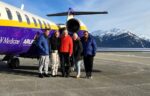 Group photo next to UW Airlift plane on tarmac.