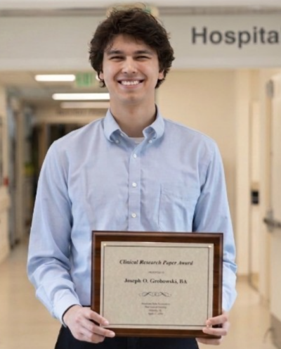 Joseph Grobowski holding his ABA Clinical Research Award